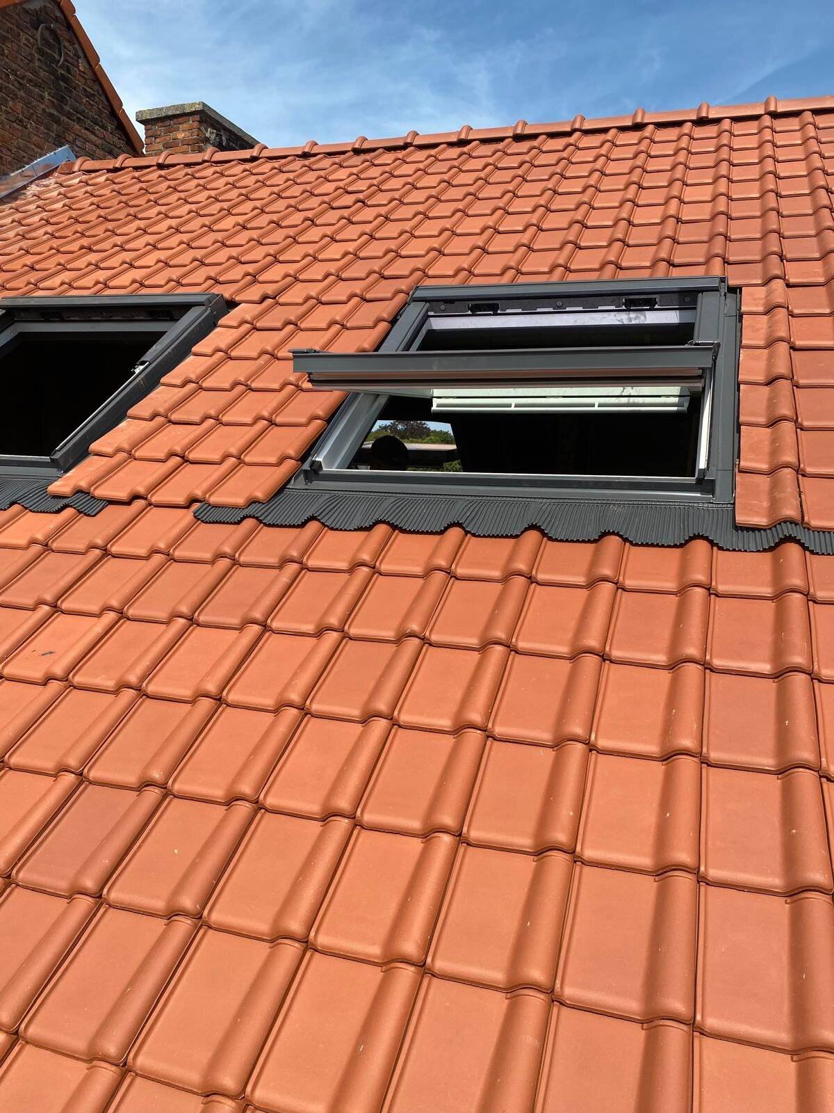 Nieuw hellend dak met twee Velux dakramen, netjes geïnstalleerd.