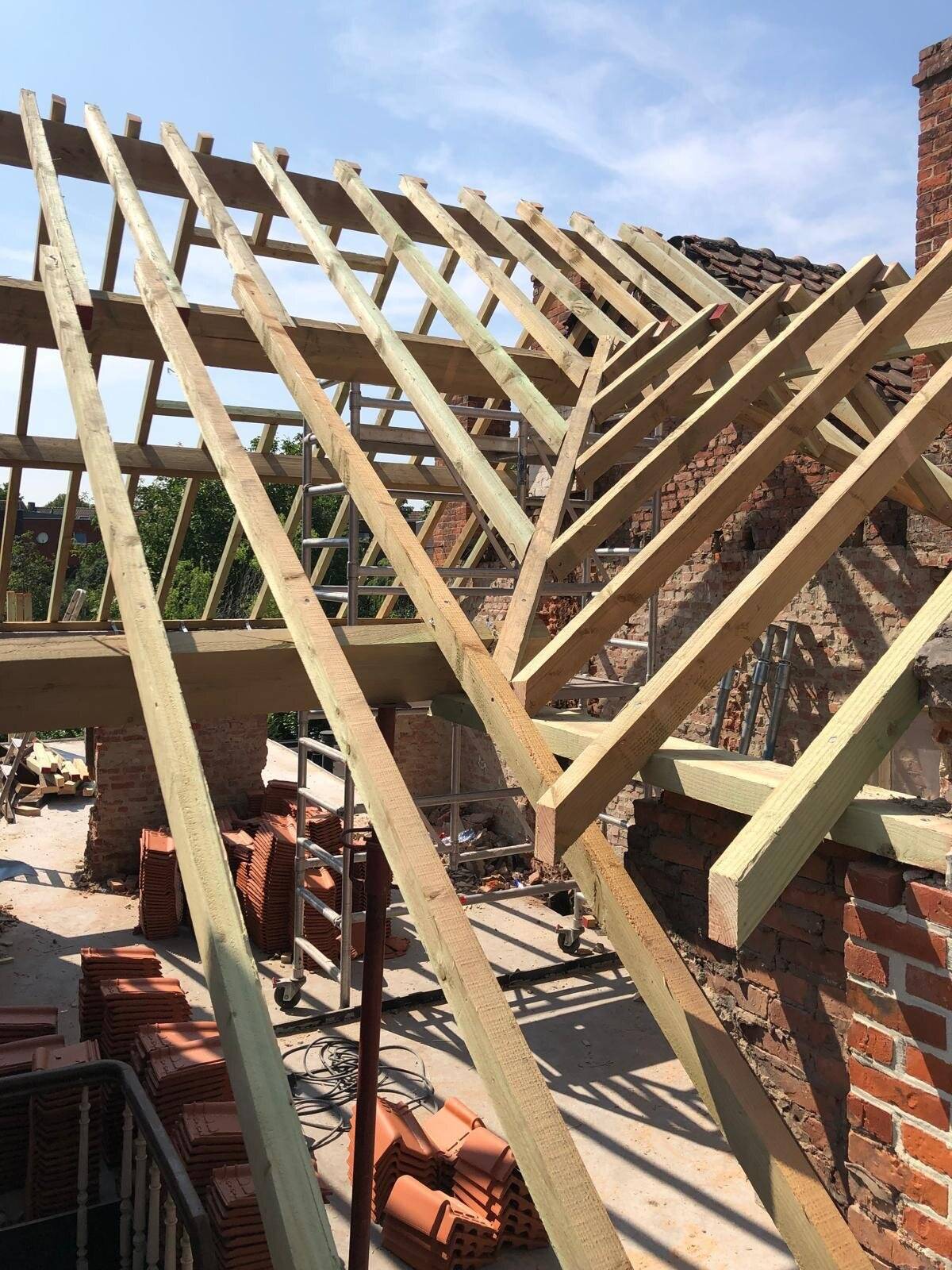 Nieuwe houten dakconstructie van een hellend dak in aanbouw.