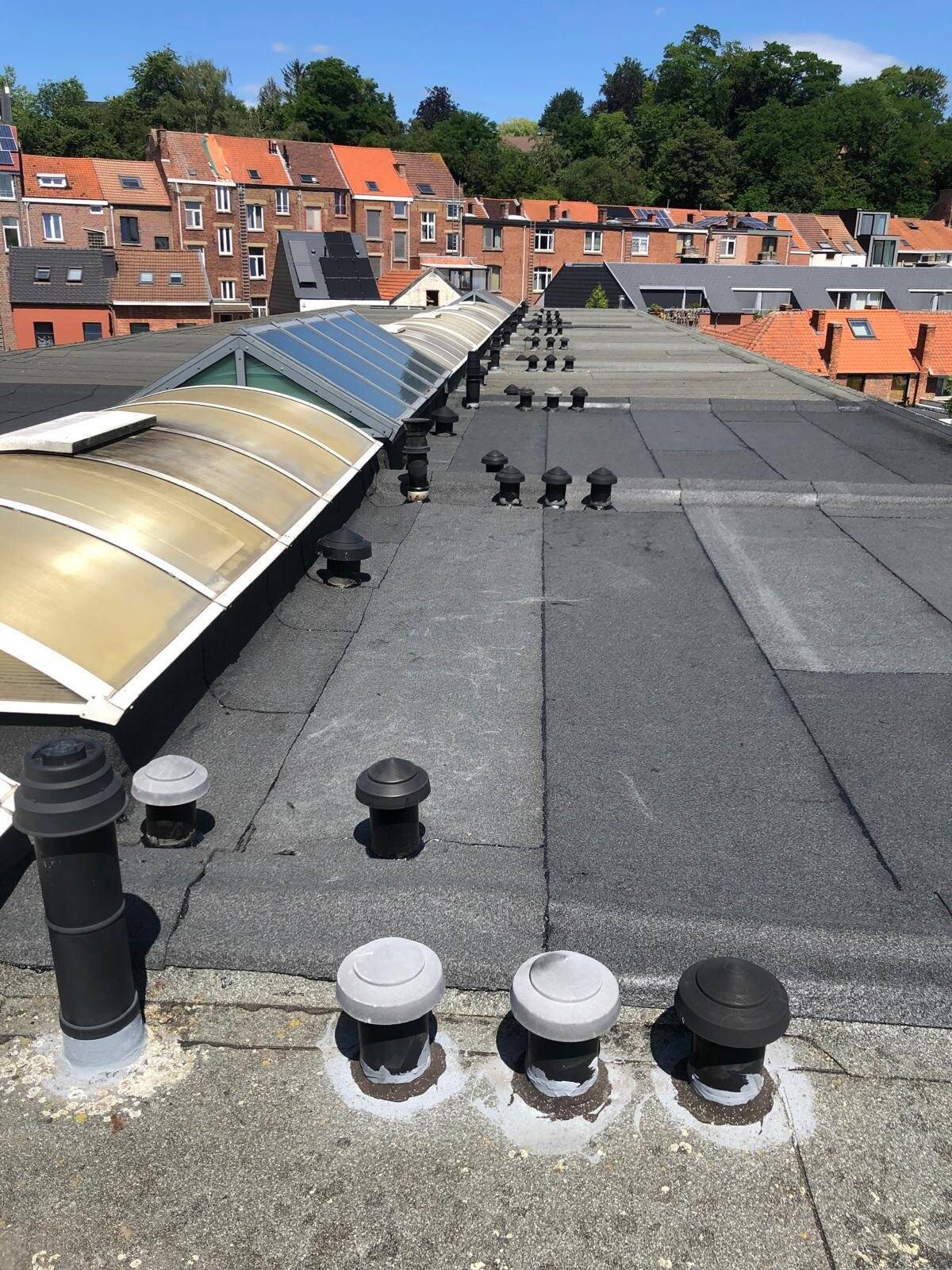 Groot plat dak met dakkoepels en ventilatieopeningen.